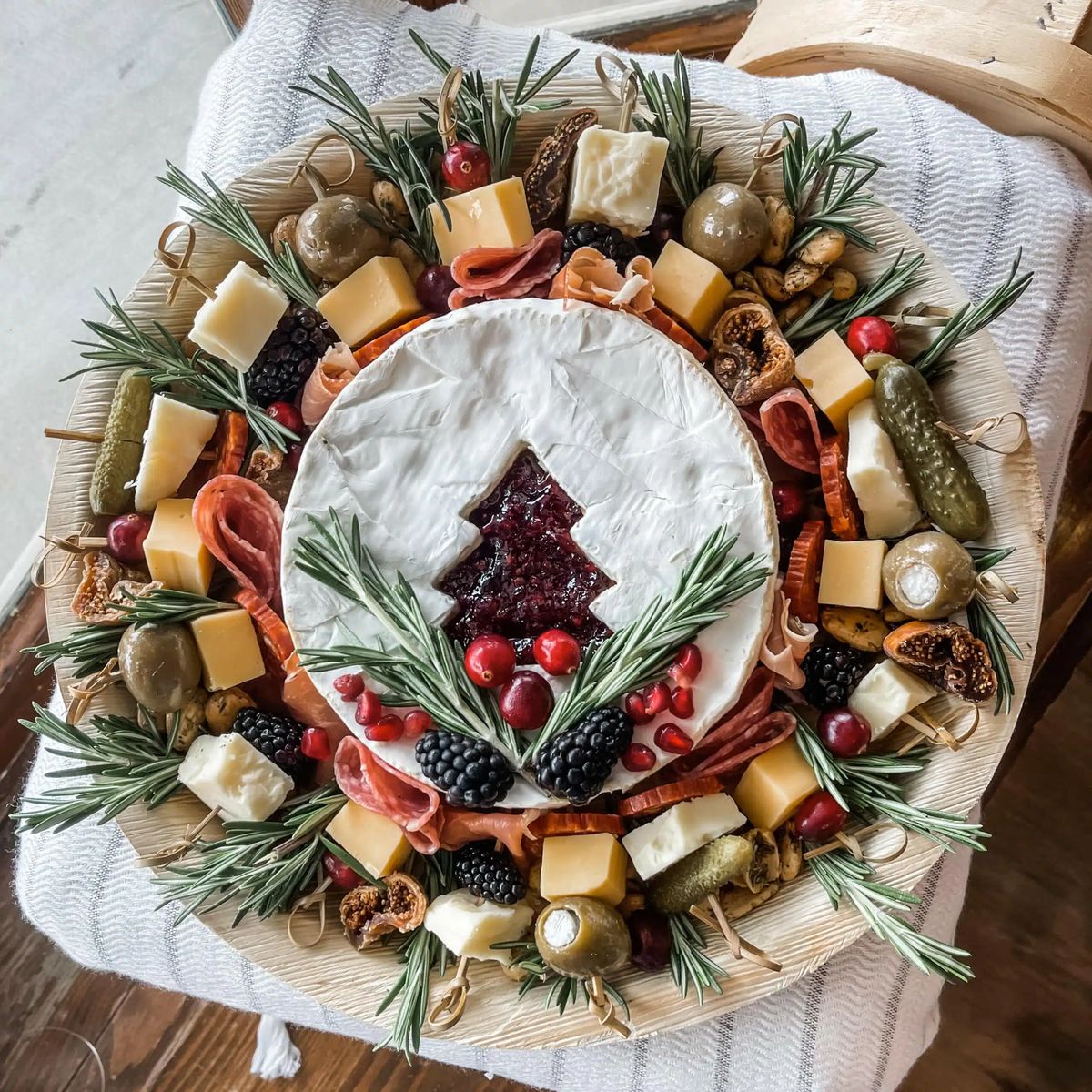 Festive Christmas charcuterie arrangement on a personalized charcuterie board with cheeses, meats and holiday fruits, styled for a stunning custom holiday display.