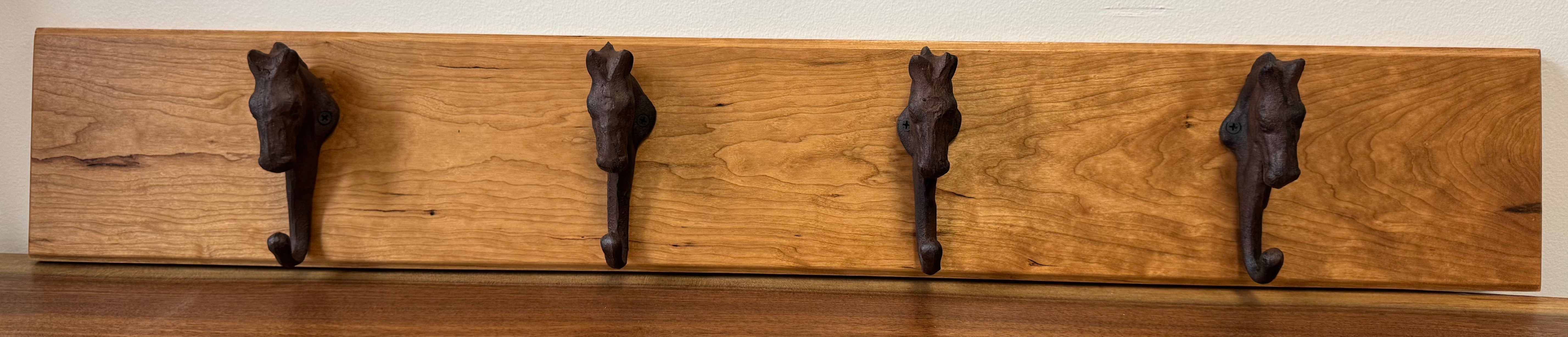 Handcrafted wood wall hanger featuring four vintage-style horse-head metal hooks, perfect for coats, bags, or home decor.
