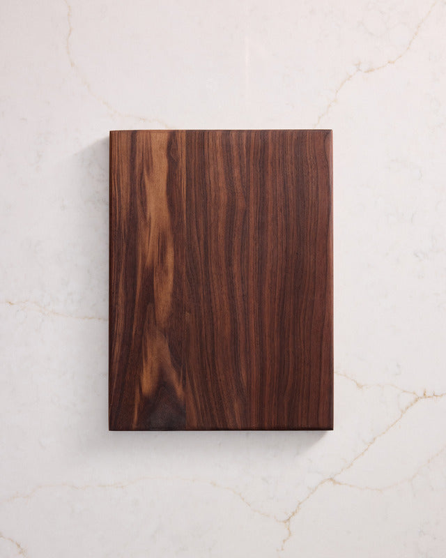 Small walnut cutting board displayed on counter, compact style and healthiest cutting boards crafted with non toxic wood material.