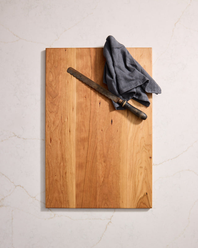 Thin cherry wood cutting board with smooth rectangular design and warm tone, best chopping board and safest cutting board material.
