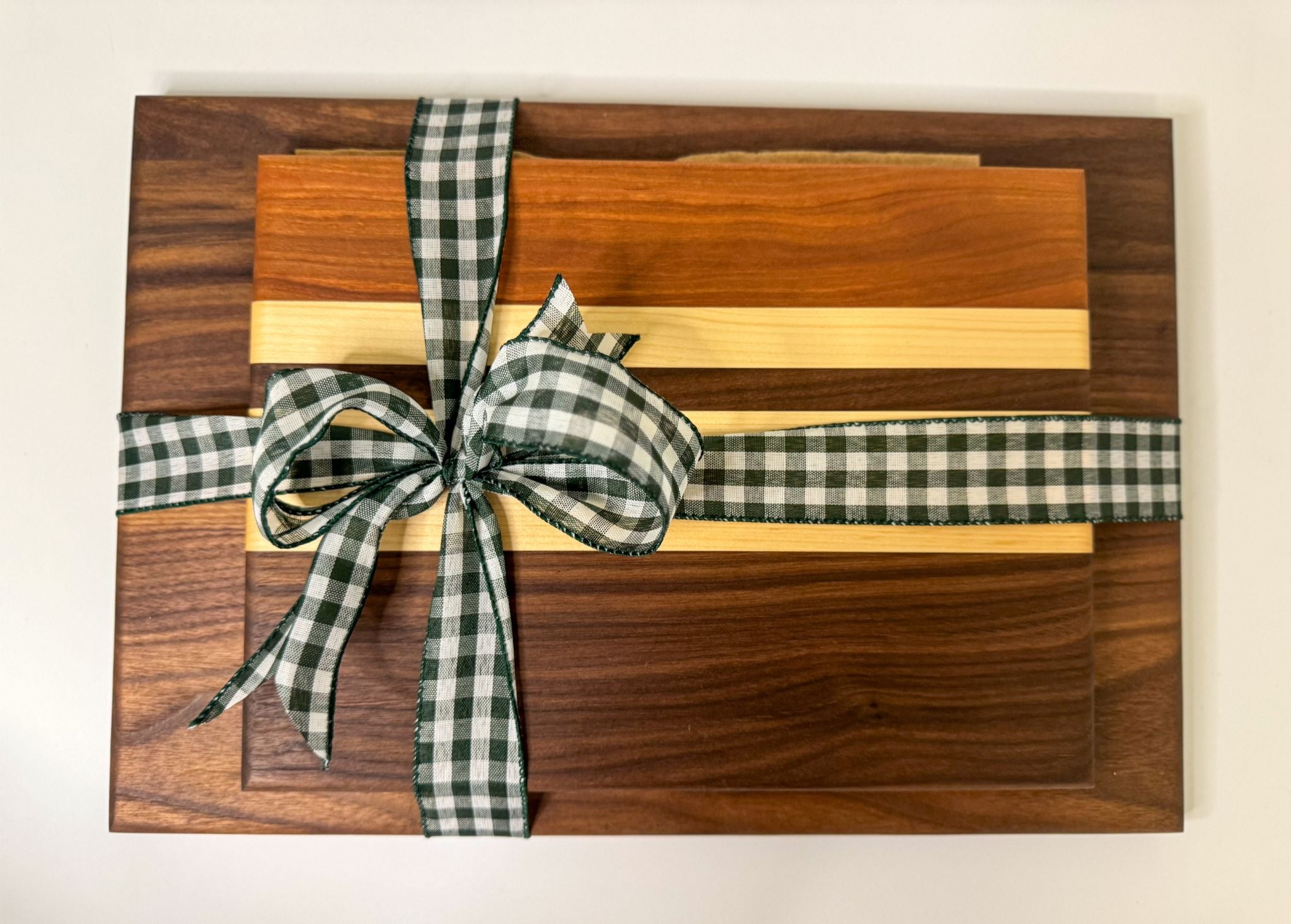 Custom wood cutting boards tied with ribbon, wooden serving tray style that makes a thoughtful hostess gift idea.