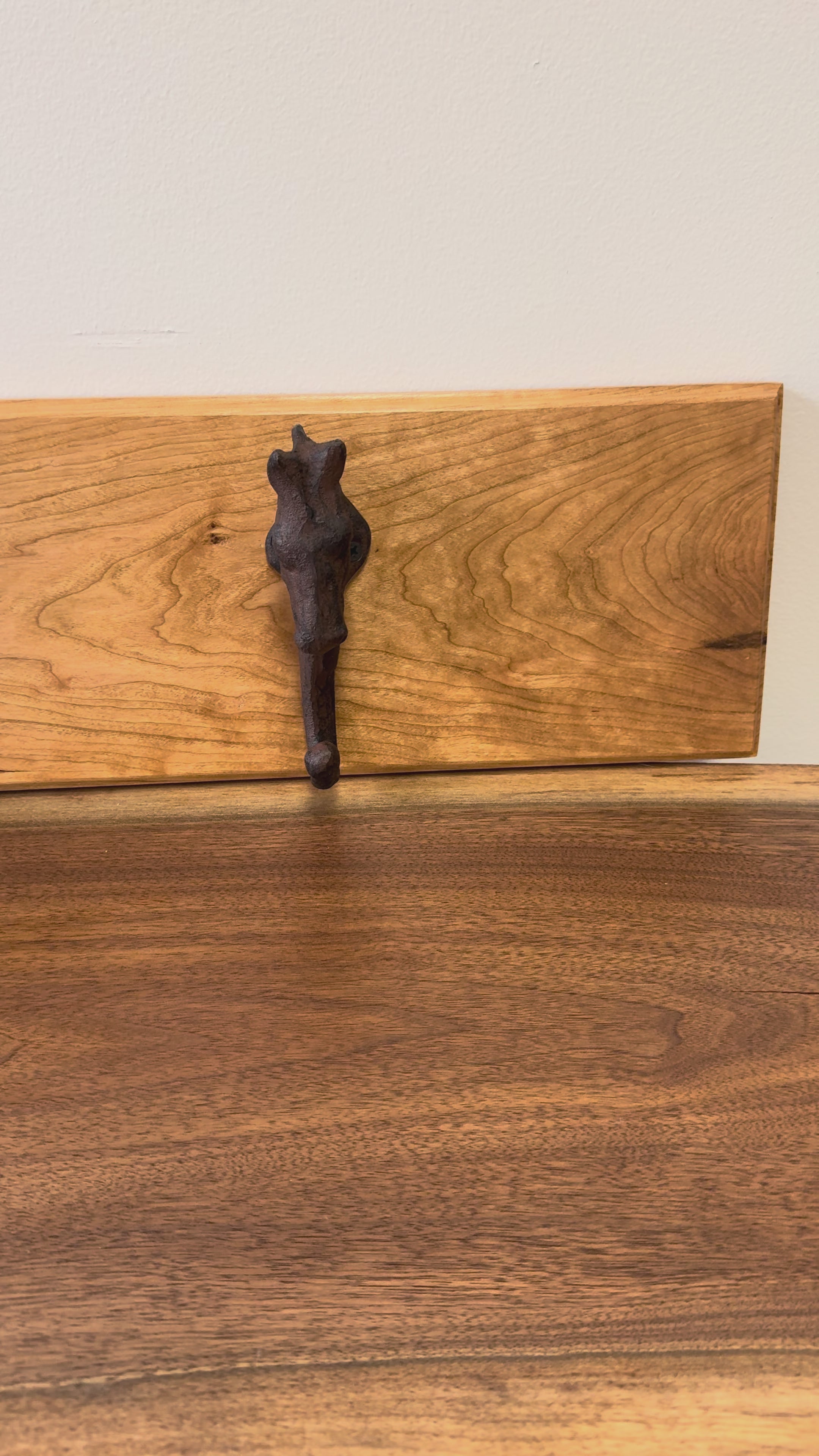 Wooden wall rack with a rustic cast iron horse-head hook, a handcrafted accent piece ideal for farmhouse or western decor.