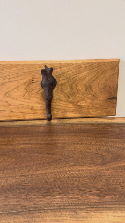 Wooden wall rack with a rustic cast iron horse-head hook, a handcrafted accent piece ideal for farmhouse or western decor.